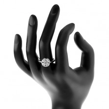 Lesklý prsteň striebornej farby, kruh zdobený čírymi zrnkami a okrúhlym zirkónom