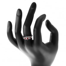 Žiarivý prsteň so zúženými ramenami, tmavočervené zrná a priezračné zirkóny