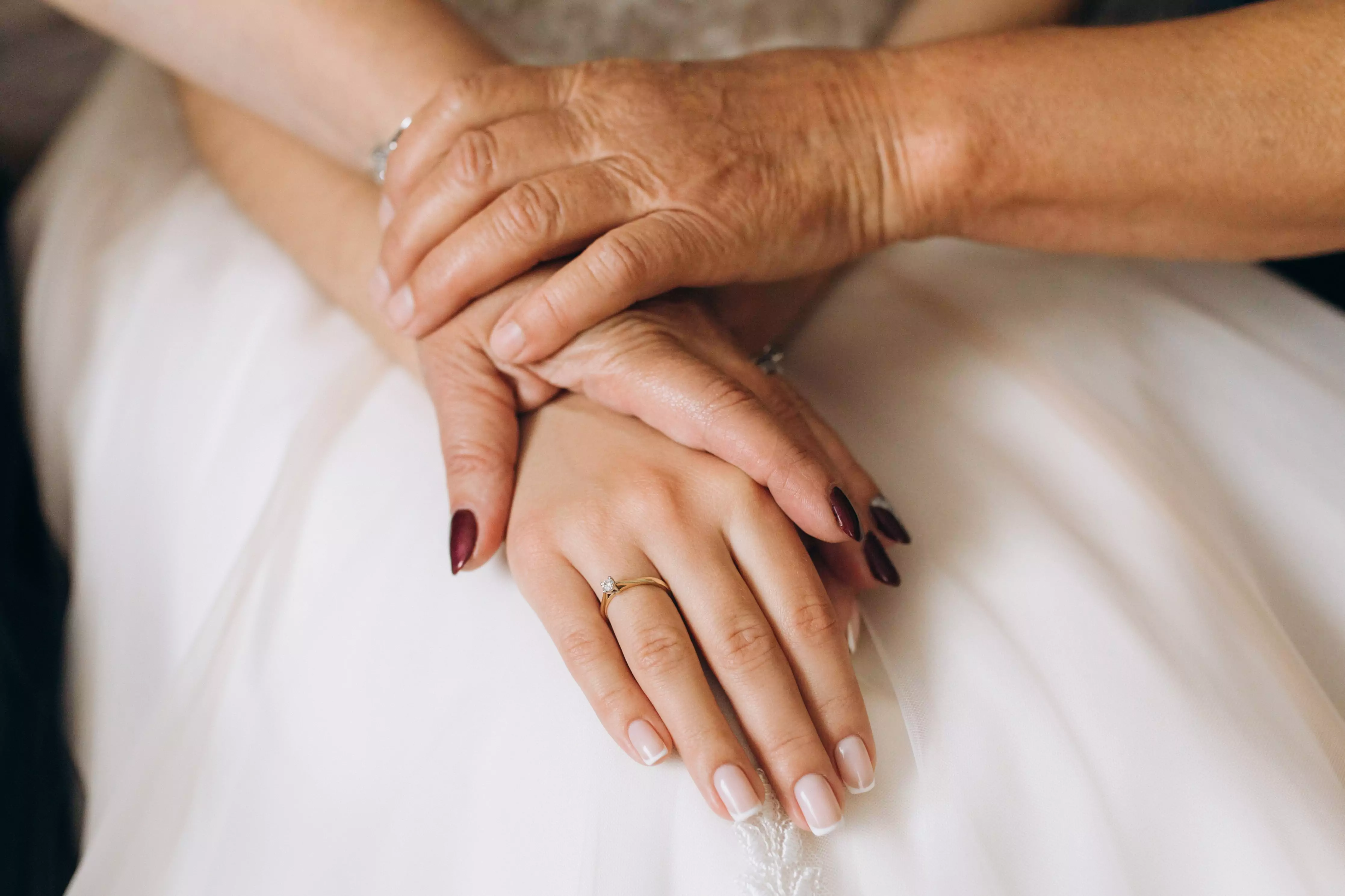 Matka, stará mama a dcéra sa držia za ruky pred svadbou so zdedeným prsteňom