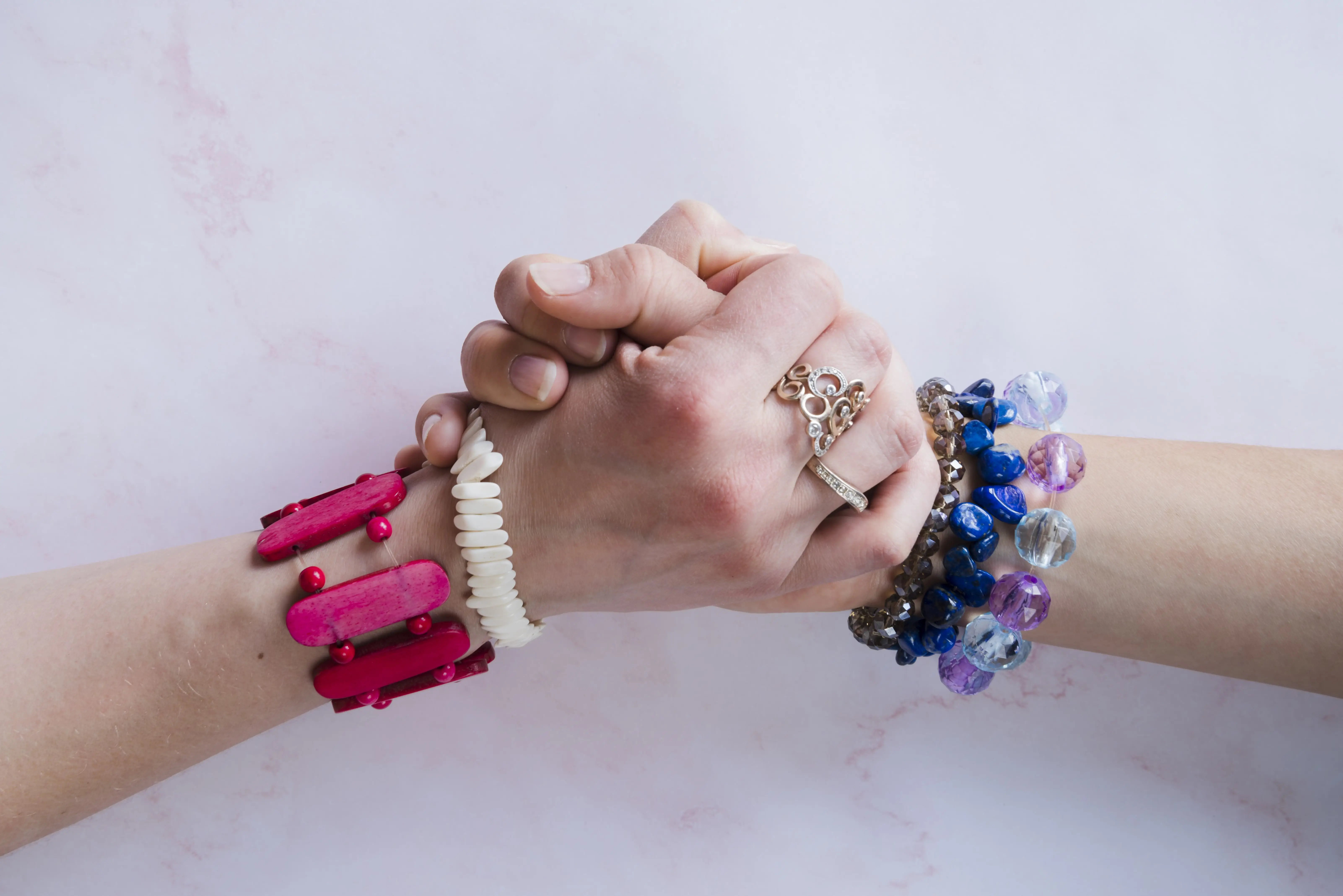 Women with beautiful colorful bracelets shake hands