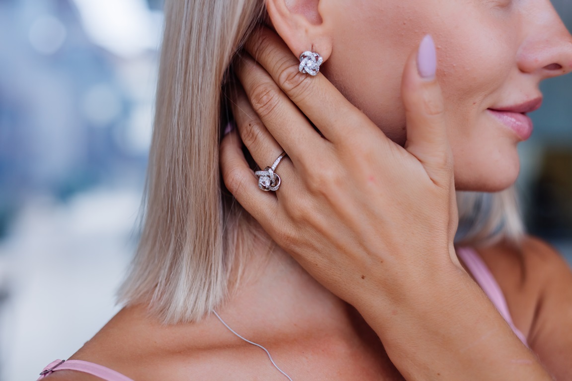 close-shot-rich-luxury-woman-dress-hand-ear-wearing-earrings-ring-finger.jpg