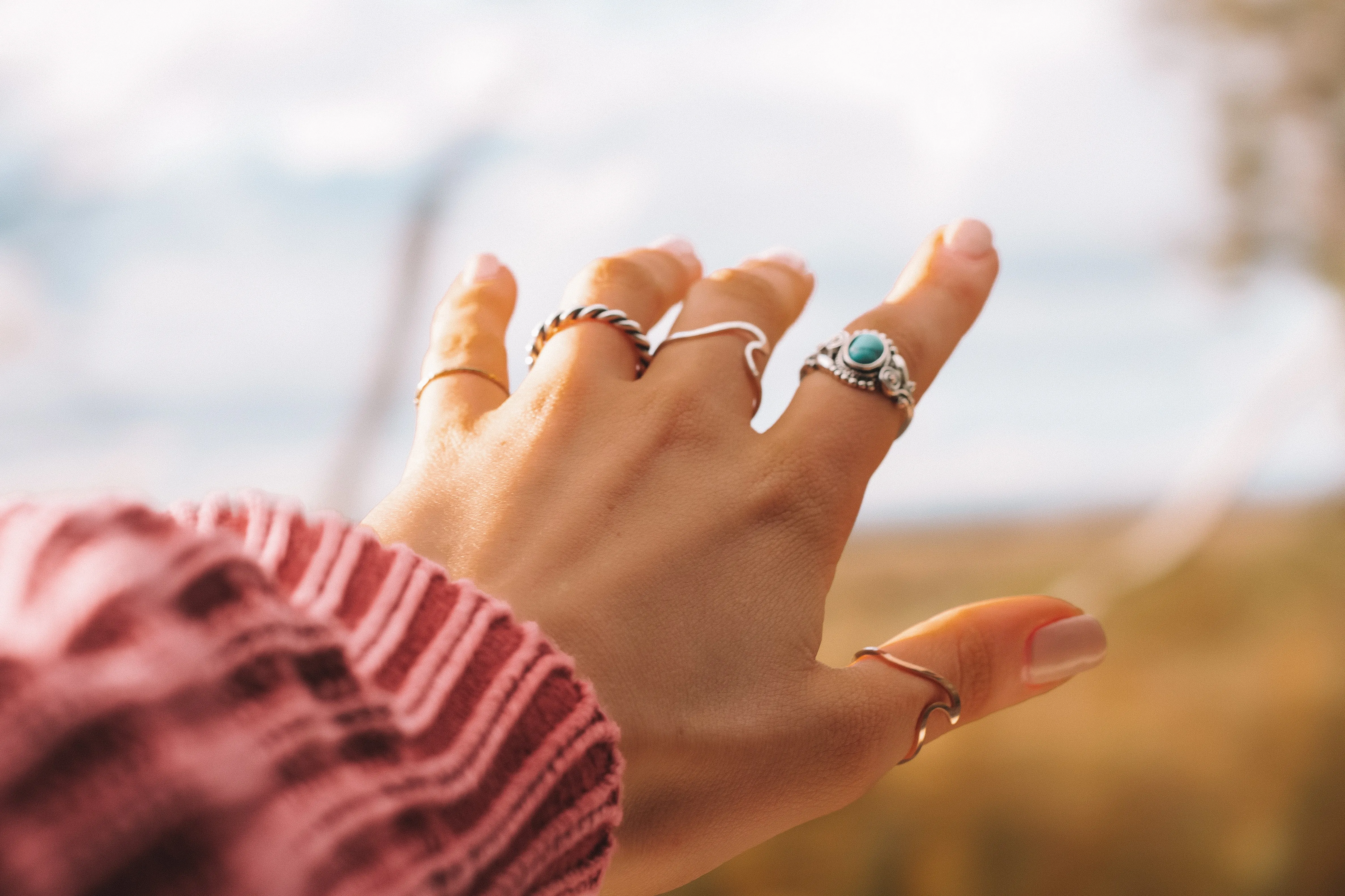 Ženska roka s srebrnimi prstani na vsakem prstu