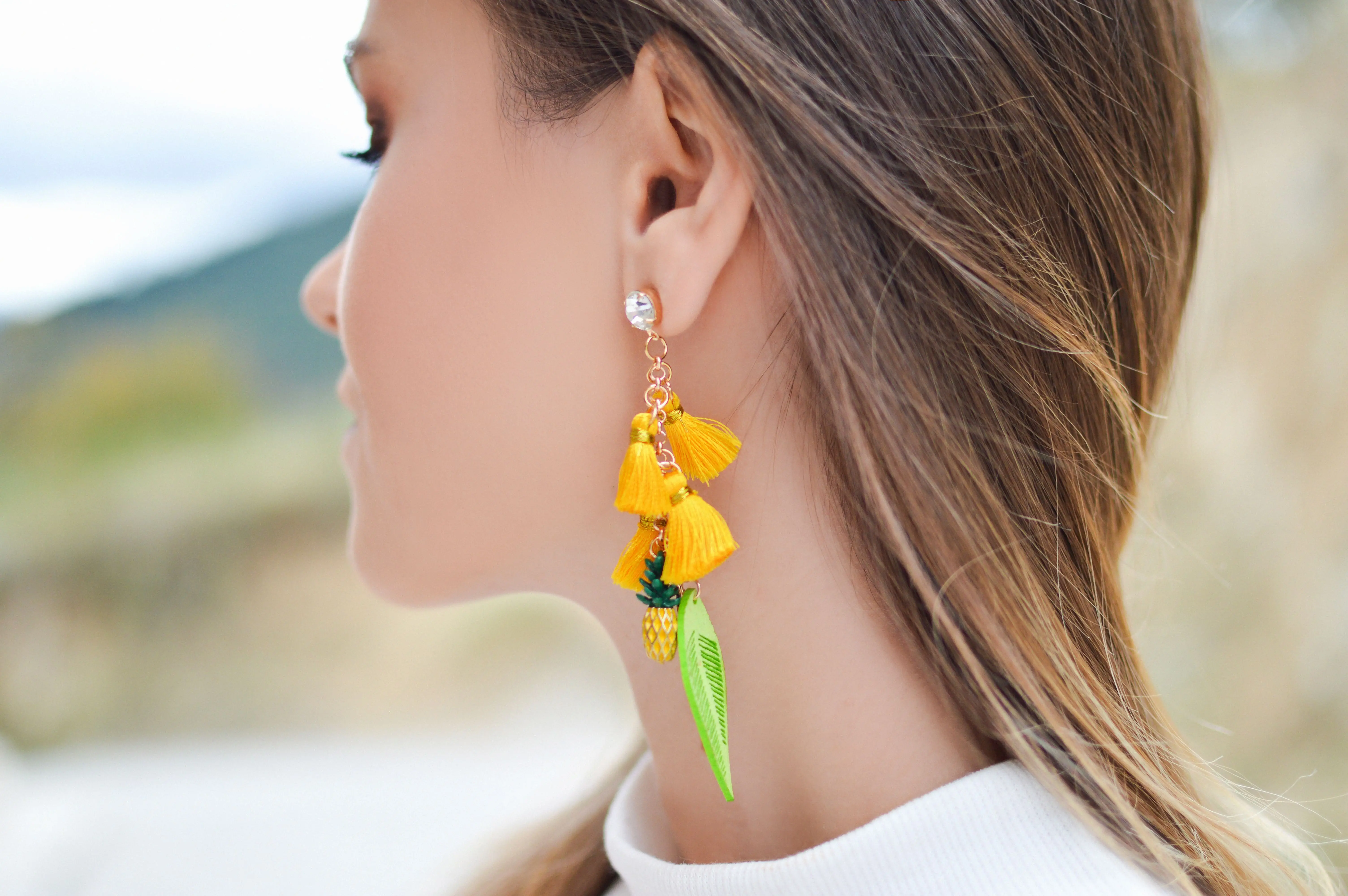 Ženska z dolgimi uhani v rumeni in zeleni barvi