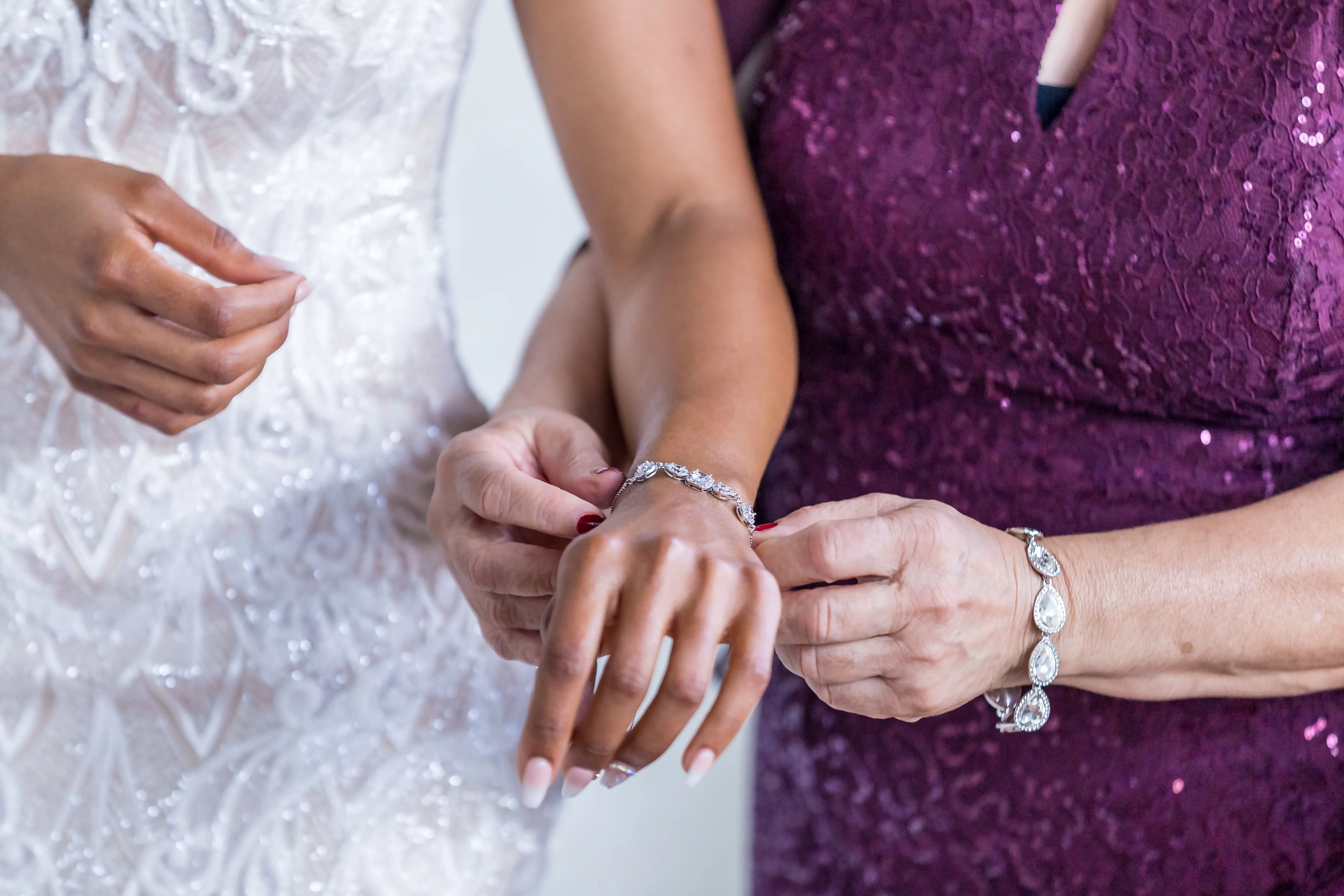 Mom clasps the bride's wedding bracelet